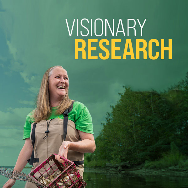 Researcher Amy Fowler holding a crab pit with the words visionary research